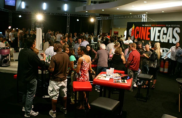 Festival attendees gather in a crowded reception space beneath a large CineVegas wall graphic.