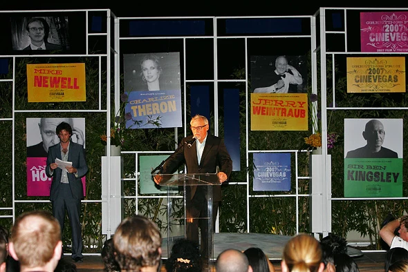 The 2007 CineVegas awards stage framed by portrait signs for Mike Newell, Charlize Theron, Jerry Weintraub, and Sir Ben Kingsley.