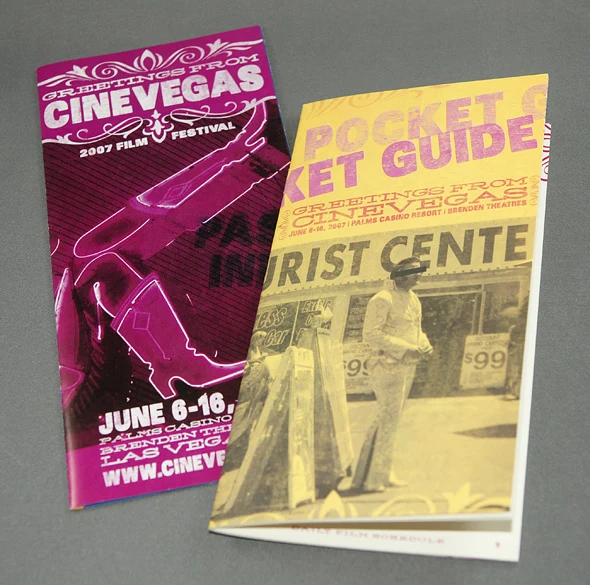 Two CineVegas pocket guides, one magenta with a neon showgirl and one yellow with Tourist Center photography.