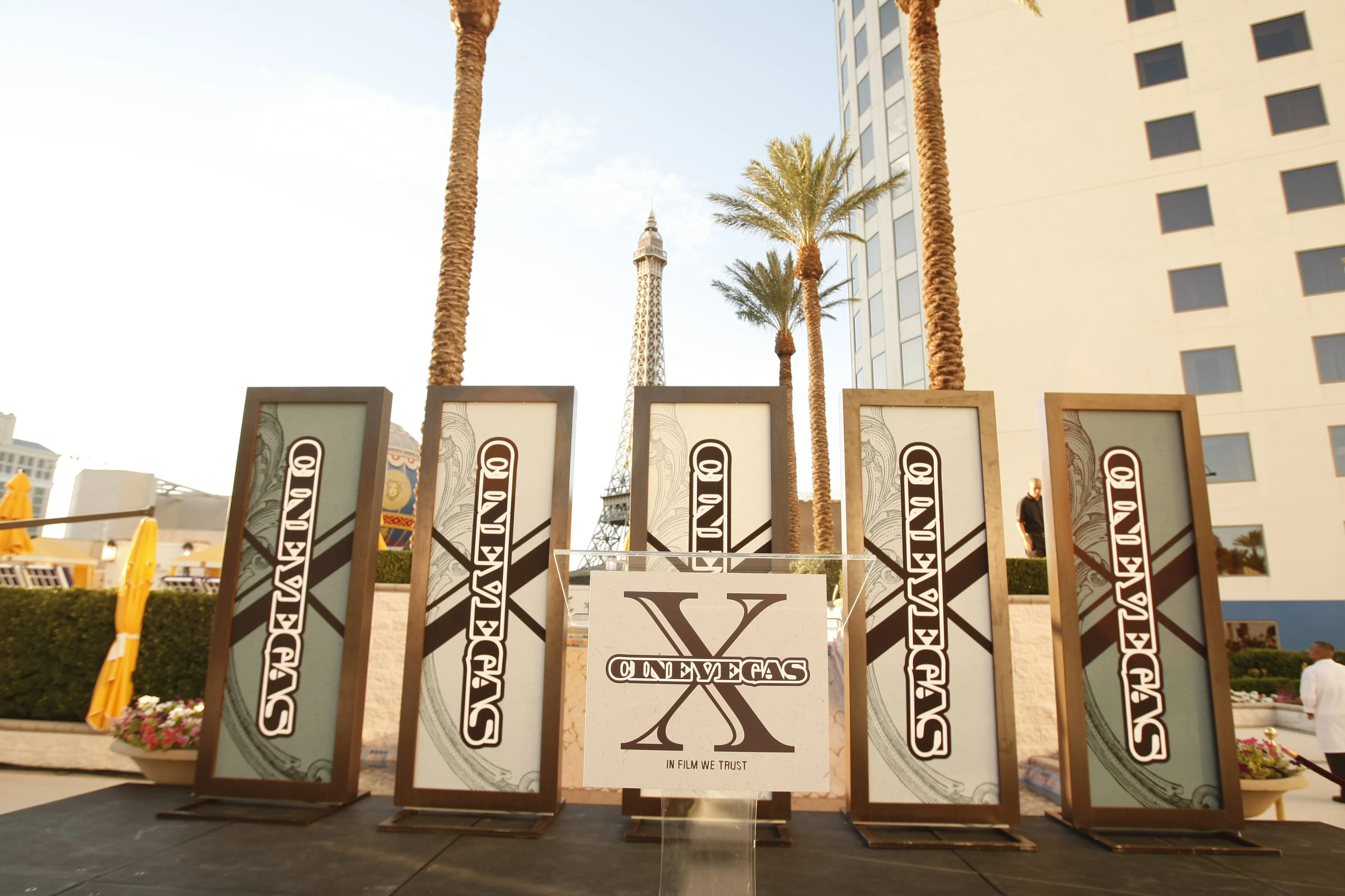 Awards ceremony boards — five freestanding CineVegas X panels at the outdoor awards event, the Paris Las Vegas Eiffel Tower replica visible behind them.