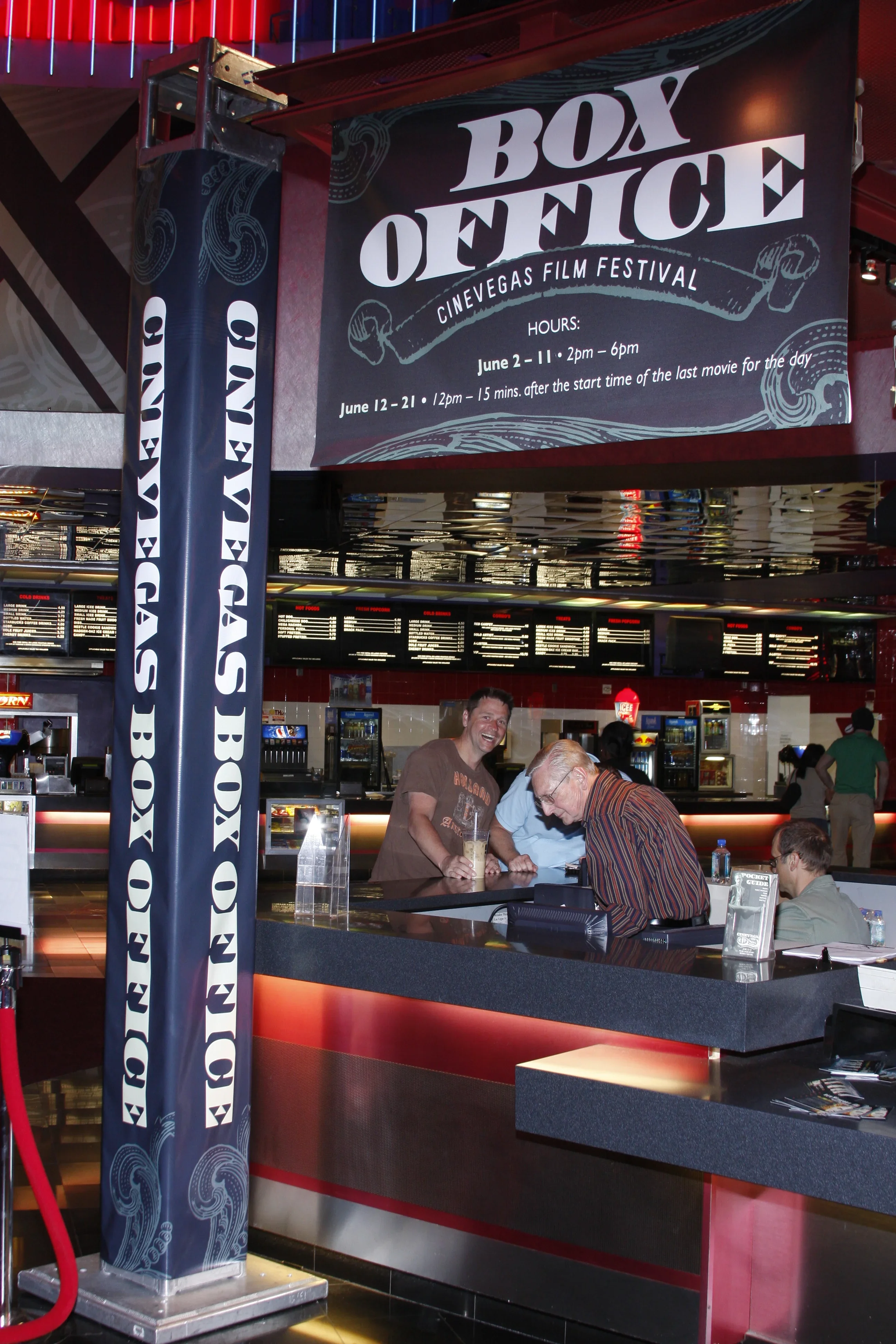 Box office signage — the CineVegas ticketing counter at the Palms, photographed from overhead. The logo ornament runs across the full fascia of the counter.