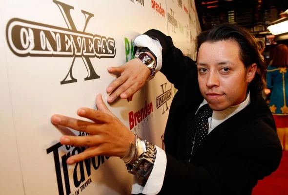 A festival guest poses in front of a CineVegas X sponsor wall at the Palms Casino Resort.